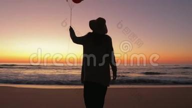带着<strong>气球</strong>在沙滩上散步的女人